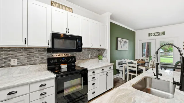 a kitchen with granite countertop a sink stainless steel appliances and cabinets