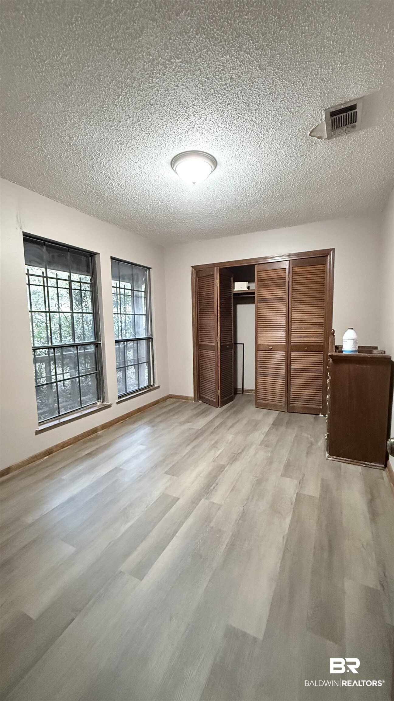 4131 Springdale Road Mobile, AL 36609 - Photo 24 of 28 Unfurnished bedroom with a closet, a textured ceiling, and light wood-style floors