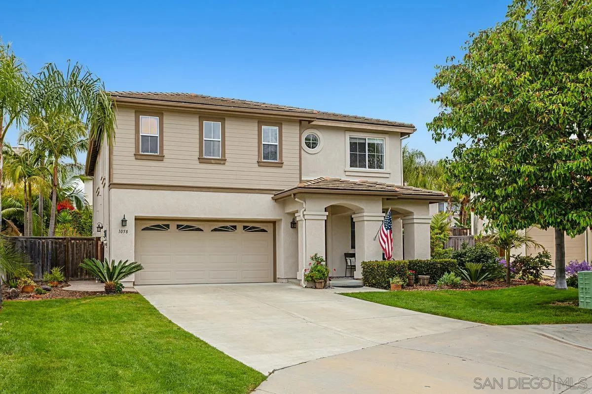 1058 Bells Drive Oceanside, CA 92057 - Photo 1 of 31 a front view of a house with a garden and garage
