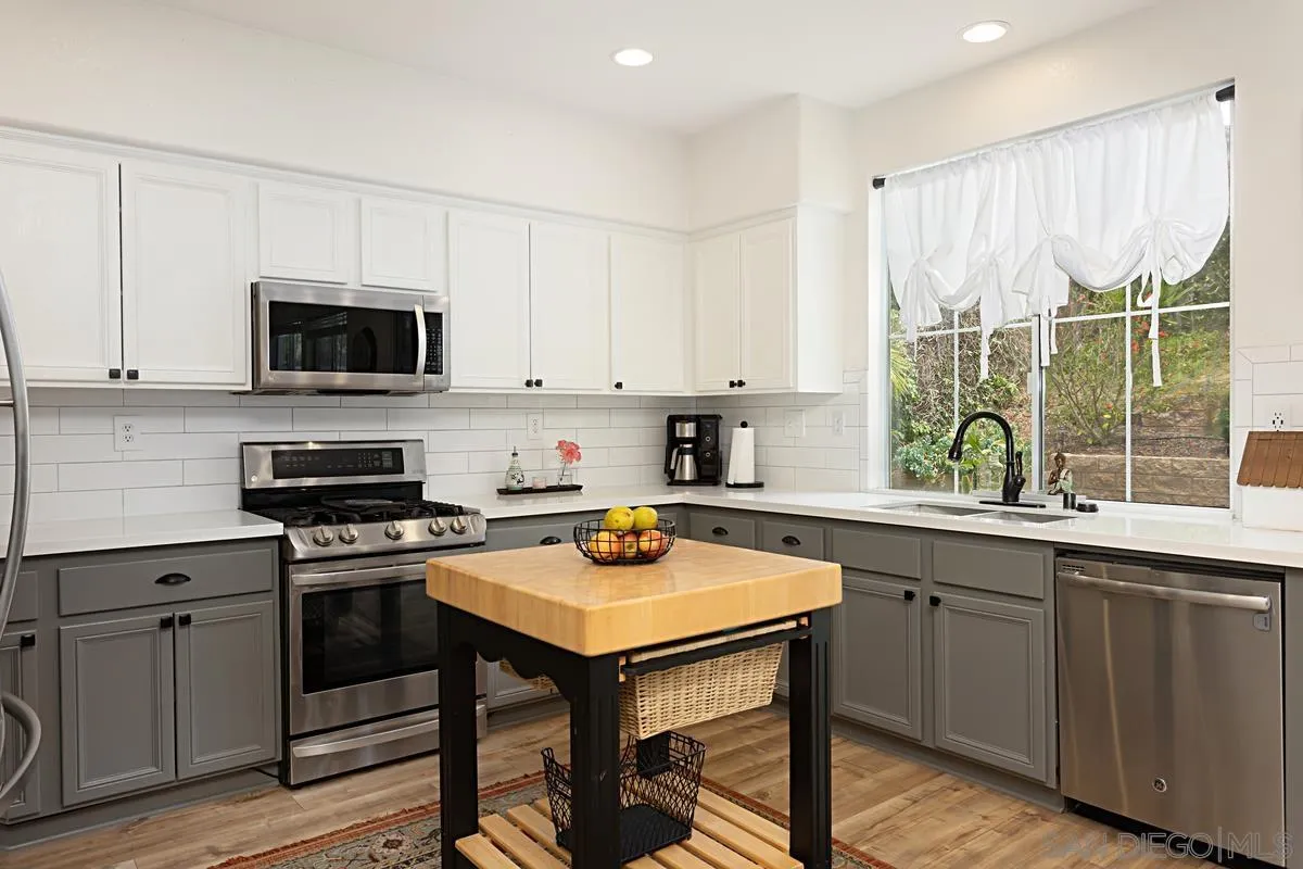 1058 Bells Drive Oceanside, CA 92057 - Photo 15 of 31 a kitchen with a stove a sink and a microwave