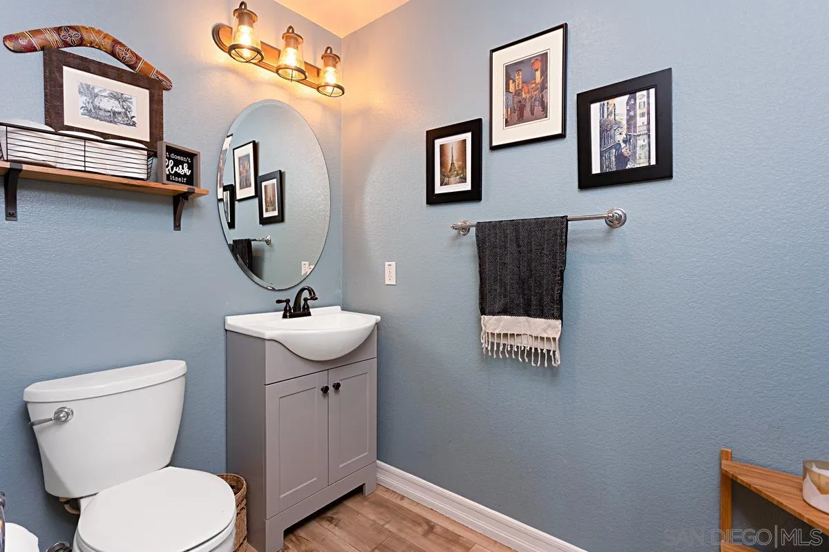 1058 Bells Drive Oceanside, CA 92057 - Photo 16 of 31 a bathroom with a toilet a sink and mirror