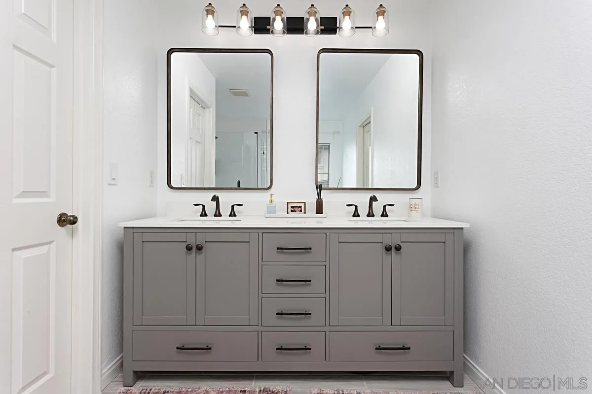1058 Bells Drive Oceanside, CA 92057 - Photo 20 of 31 a bathroom with double vanity sinks and a mirror
