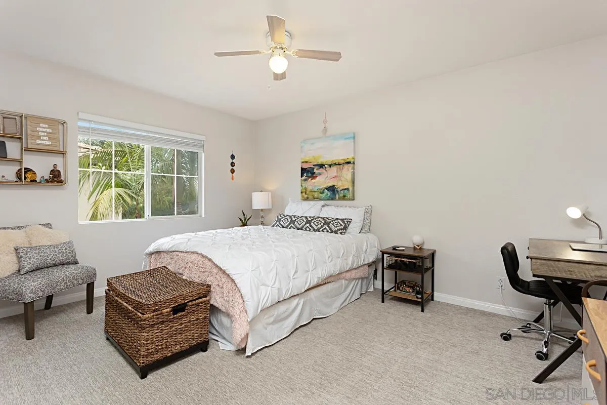 1058 Bells Drive Oceanside, CA 92057 - Photo 23 of 31 a bedroom with a bed a chair and a chandelier