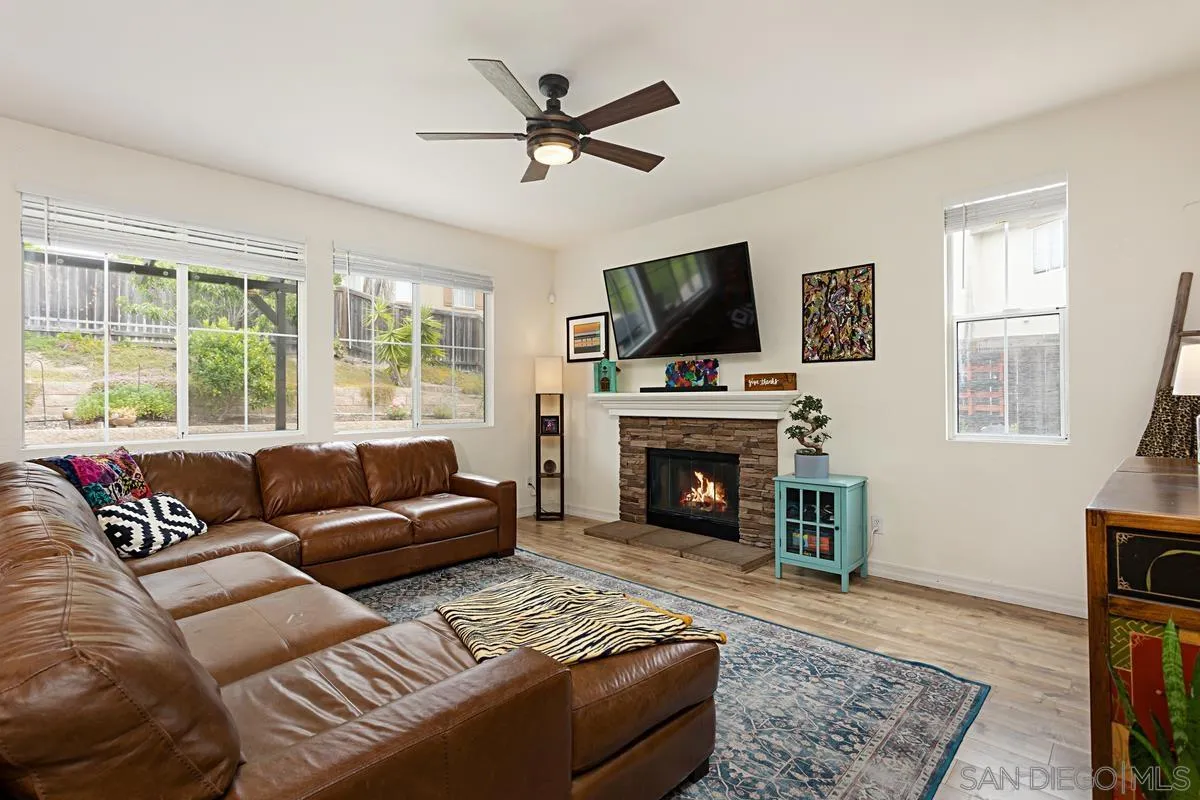 1058 Bells Drive Oceanside, CA 92057 - Photo 4 of 31 a living room with furniture a fireplace and a flat screen tv