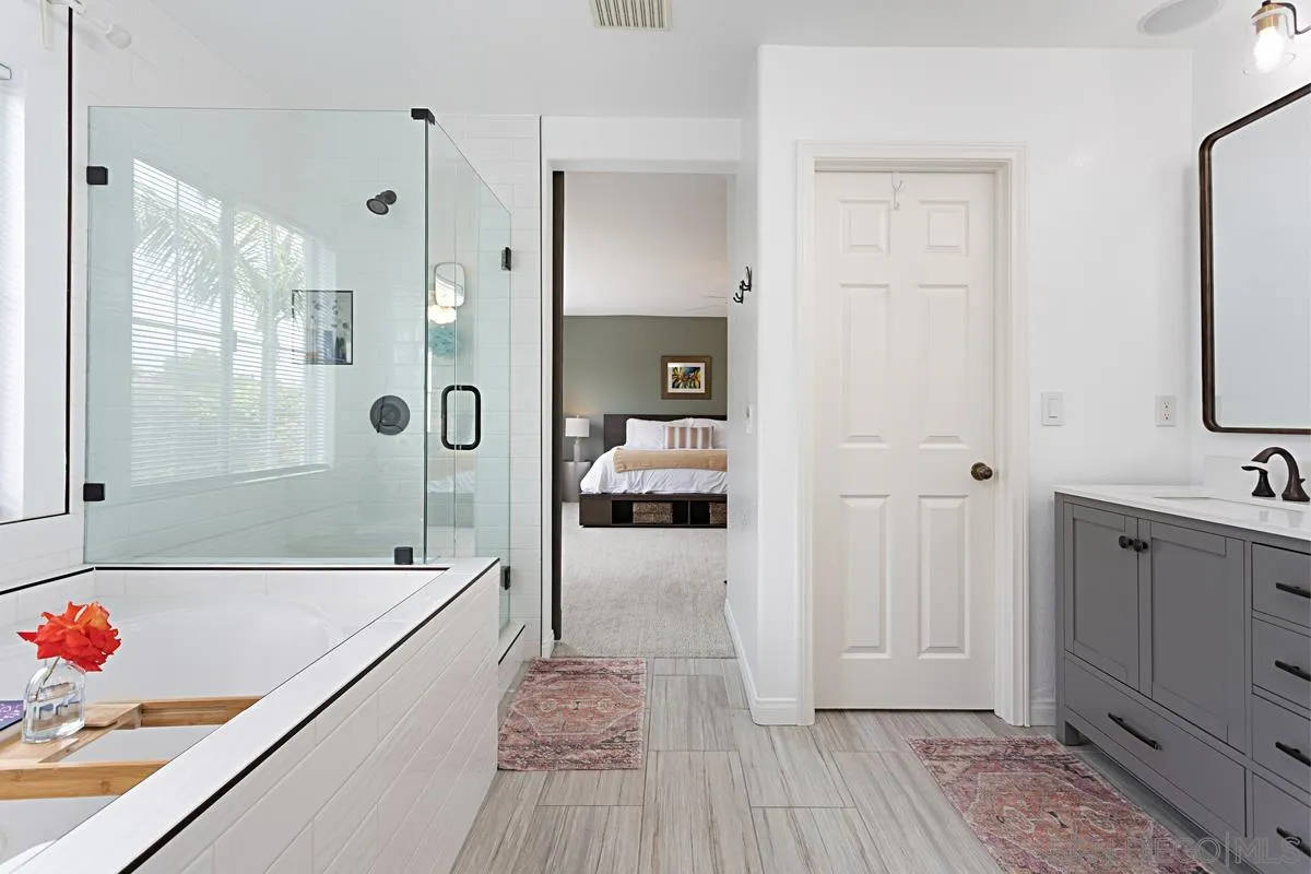 1058 Bells Drive Oceanside, CA 92057 - Photo 6 of 31 a en suite bathroom with a granite countertop tub shower and mirror