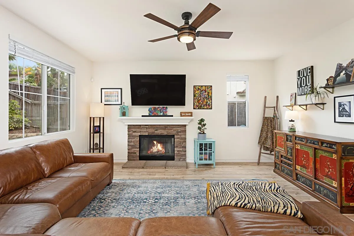 1058 Bells Drive Oceanside, CA 92057 - Photo 10 of 31 a living room with furniture a flat screen tv and a fireplace