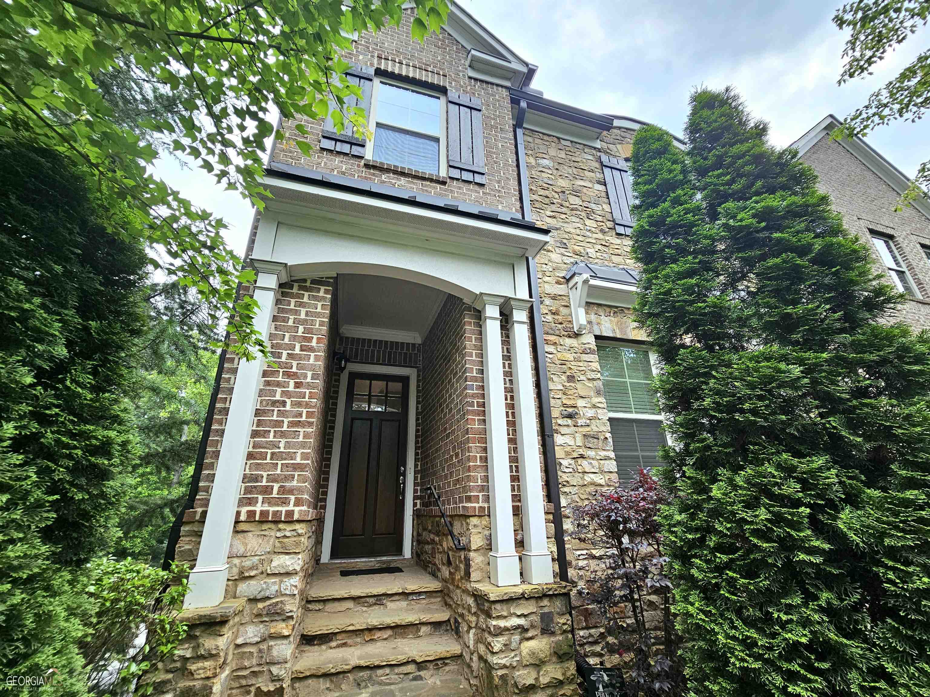 a front view of a house with plants