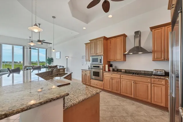 a kitchen with stainless steel appliances granite countertop a sink counter space cabinets and a stove