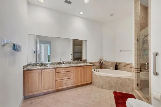 a bathroom with a granite countertop double vanity sink a mirror and a