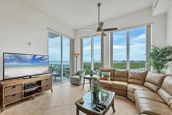 a living room with furniture a flat screen tv and a large window