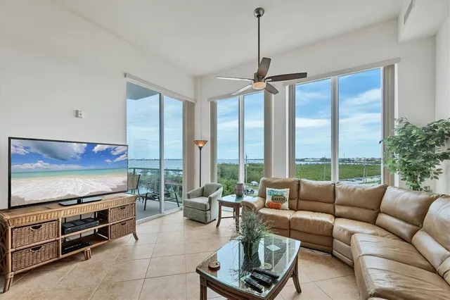a living room with furniture a flat screen tv and a large window