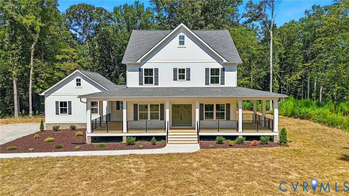 a view of a white house with large windows and a small yard