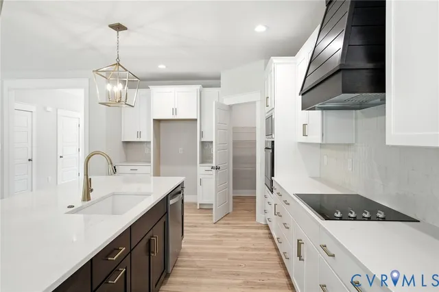 a large kitchen with stainless steel appliances granite countertop a large counter top and wooden floors