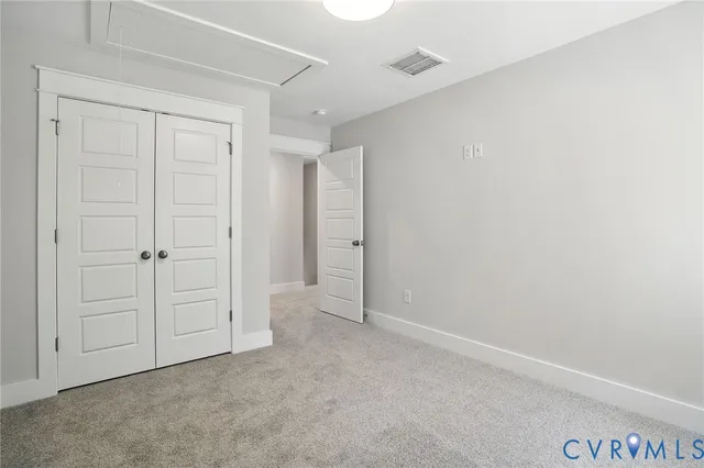 an empty room with windows and closet