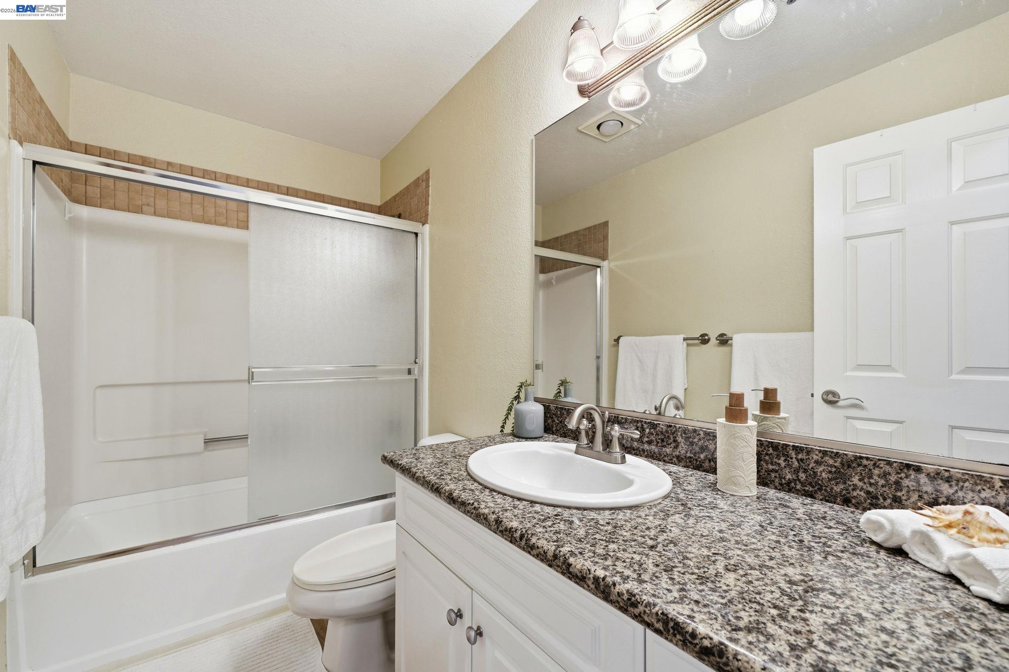 490 Bollinger Canyon Lane, Unit 367 San Ramon, CA 94582 - Photo 23 of 32 a bathroom with a granite countertop sink a toilet and shower