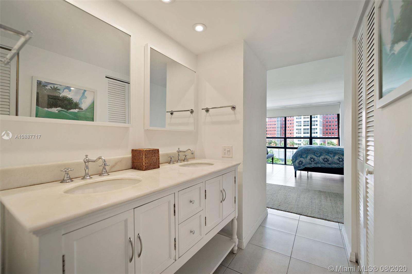 1450 Brickell Bay Drive, Unit 612 Miami, FL 33131 - Photo 19 of 25 a spacious bathroom with a double vanity sink a mirror and shower