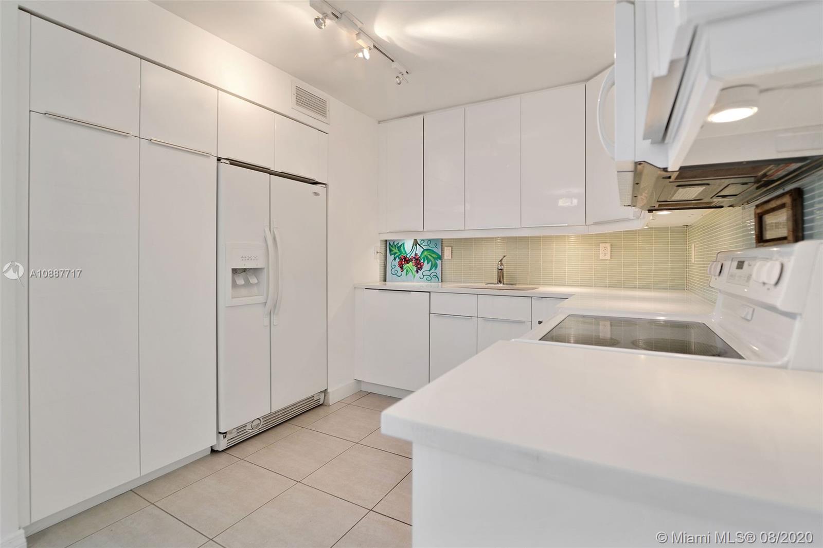 1450 Brickell Bay Drive, Unit 612 Miami, FL 33131 - Photo 5 of 25 a kitchen with cabinets and white appliances