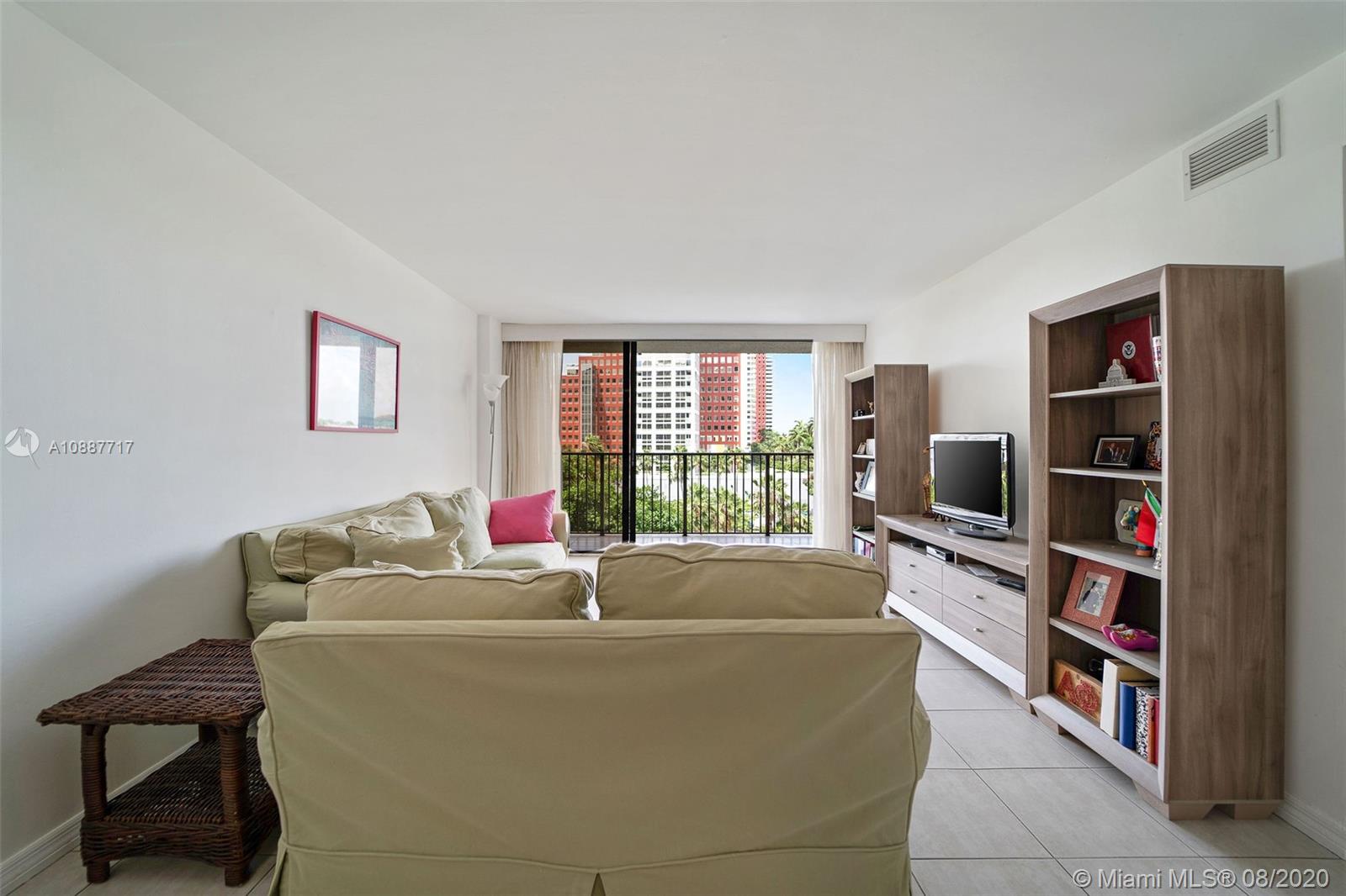 1450 Brickell Bay Drive, Unit 612 Miami, FL 33131 - Photo 6 of 25 a living room with couch and a flat screen tv
