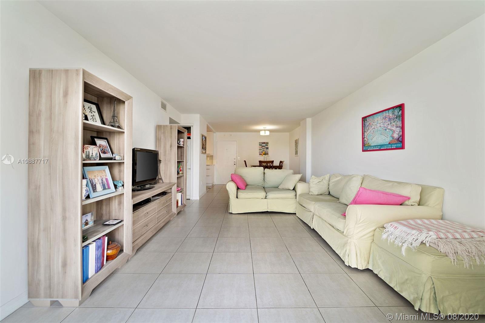 1450 Brickell Bay Drive, Unit 612 Miami, FL 33131 - Photo 9 of 25 a living room with furniture and a book shelf