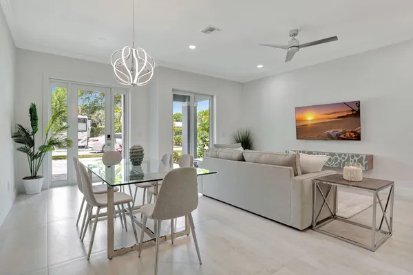 a living room with furniture a chandelier and a flat screen tv