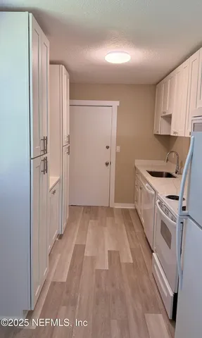 a view of a kitchen with a sink and dishwasher wooden floor