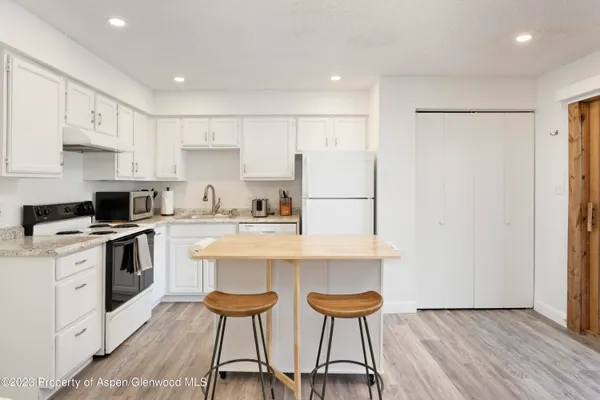 a kitchen with stainless steel appliances a stove a sink cabinets and a refrigerator