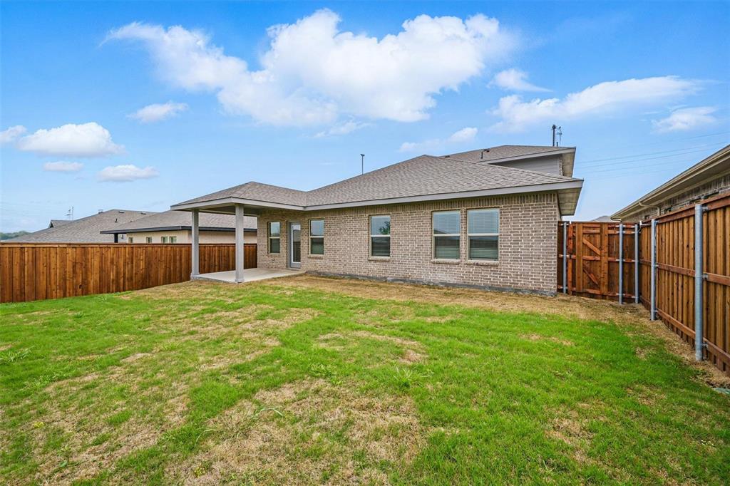 1413 Richardson Street Howe, TX 75459 - Photo 27 of 30 Expansive backyard featuring a covered patio, a full privacy fence, and a brick exterior