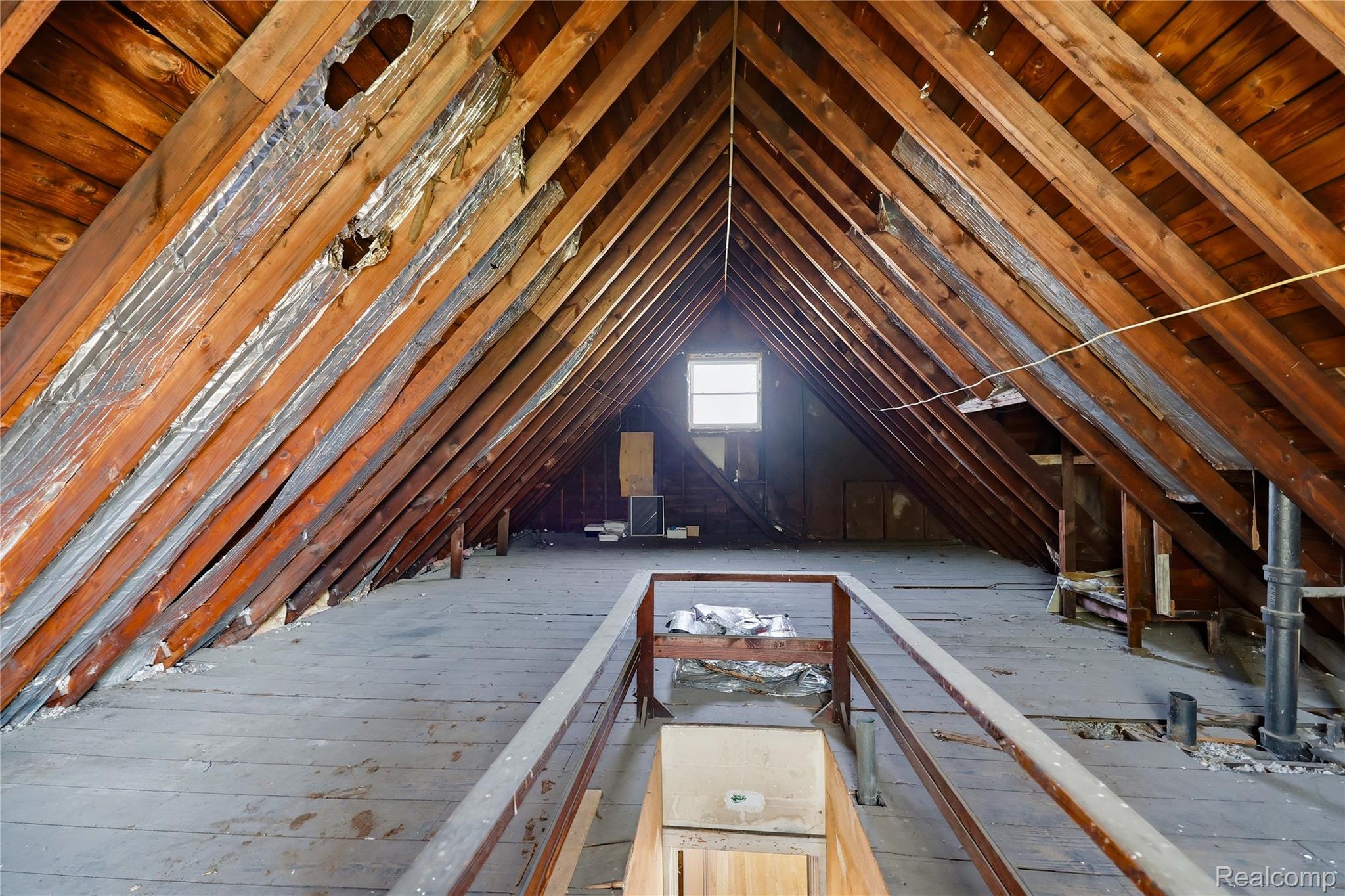 1945 Atkinson Street Detroit, MI 48206 - Photo 36 of 49 Spacious attic featuring exposed wood rafters, wood flooring, and a single window offering ambient light