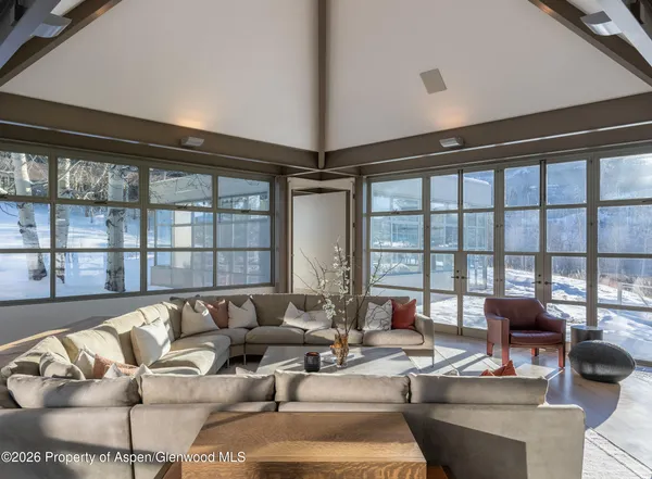 a living room with furniture and a floor to ceiling window