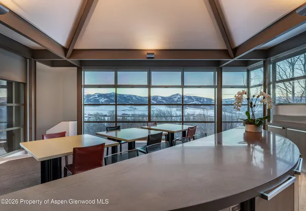 a dining room with furniture and a floor to ceiling window