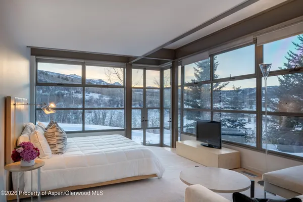 a spacious bedroom with a large bed and a large window