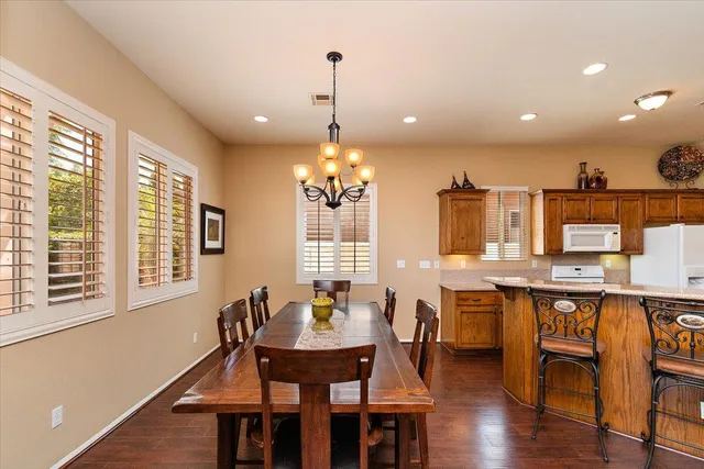 a dining room filled chandelier and wooden floor