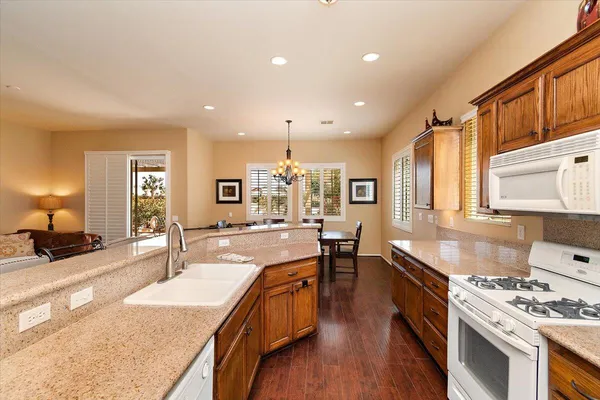 a large kitchen with stainless steel appliances granite countertop a lot of counter space and wooden floors