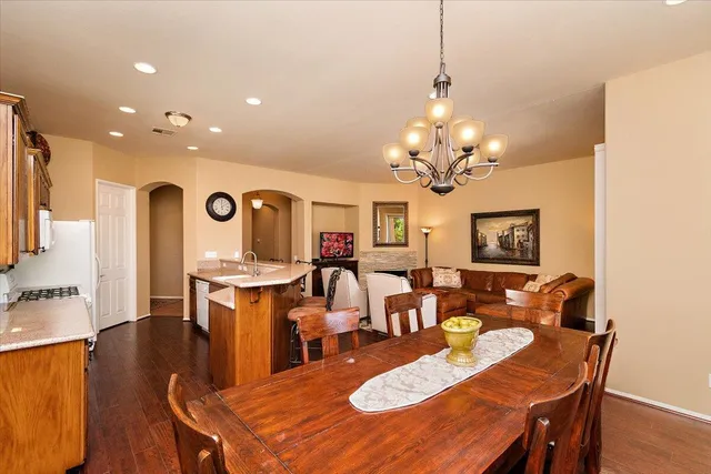 a view of a dining room with furniture a chandelier and wooden floor
