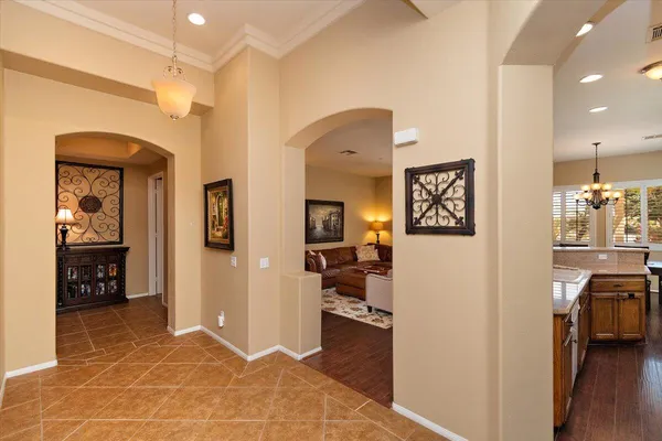 a view of a hallway with wooden floor and a living room