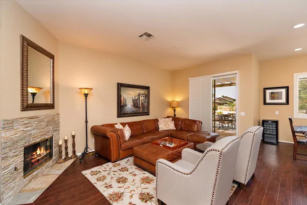 a living room with furniture a fireplace and wooden floor