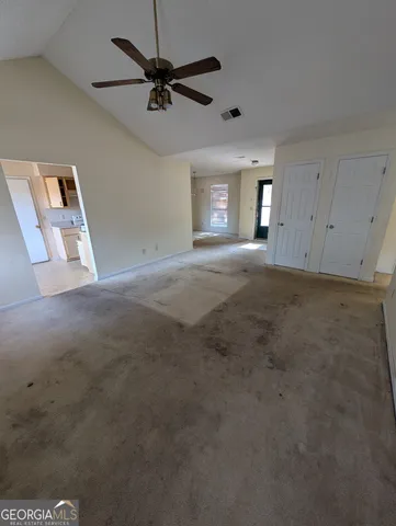 a view of a livingroom with a ceiling fan and window