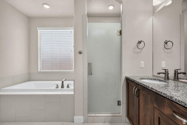 11 East 640 South Ivins, UT 84738 - Photo 25 of 44 Built-in bathtub, glass-enclosed shower, dual vanity with granite countertop, wood-finish cabinetry, and recessed lighting