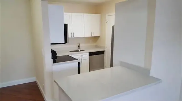 a kitchen with stainless steel appliances a sink stove and cabinets