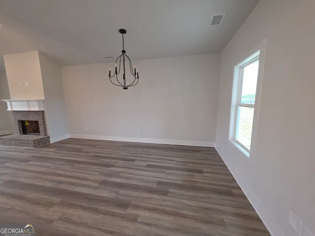 a view of a room with wooden floor and a window