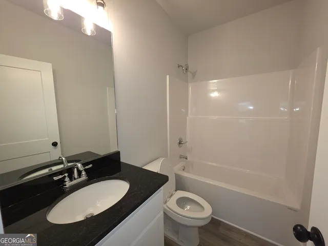 a bathroom with a sink a toilet and a mirror