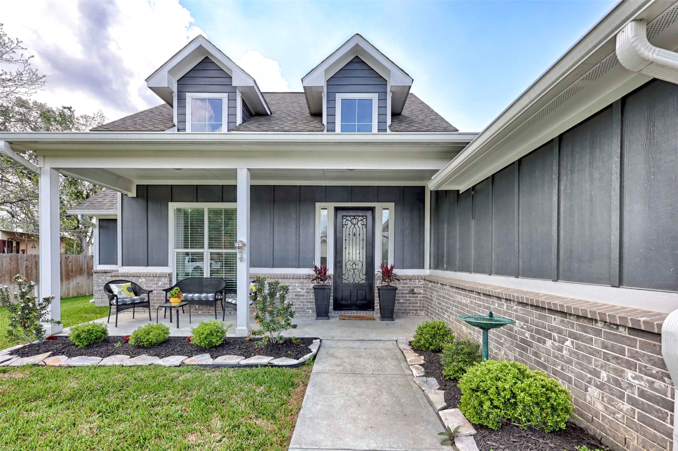 206 East Hinton Road Weimar, TX 78962 - Photo 1 of 22 Entrance to property featuring board and batten siding, a porch, a shingled roof, and brick siding