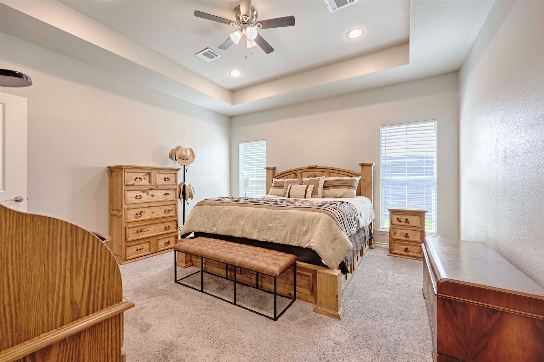 206 East Hinton Road Weimar, TX 78962 - Photo 11 of 22 Bedroom with recessed lighting, light colored carpet, a ceiling fan, multiple windows, and a raised ceiling