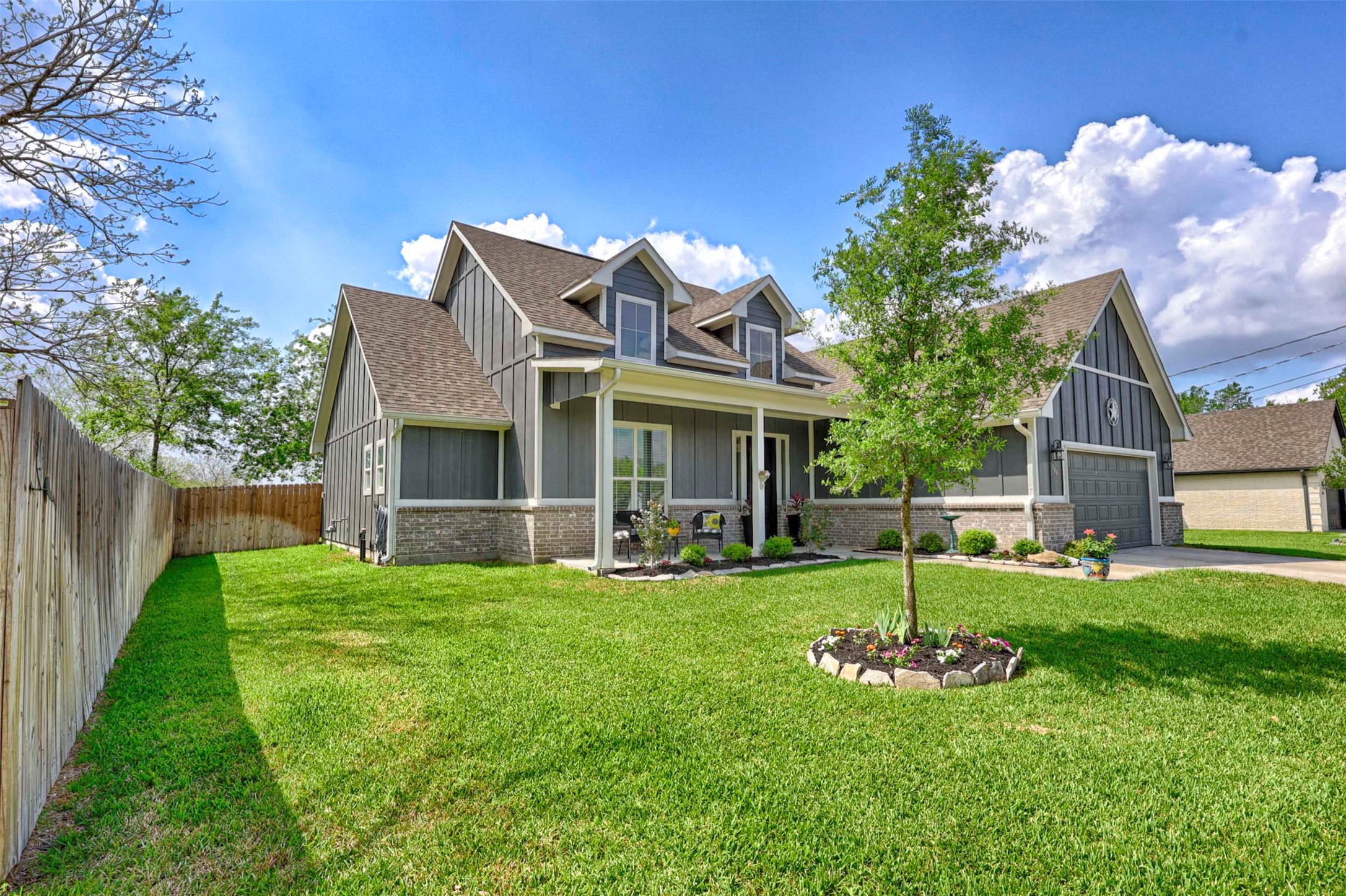 206 East Hinton Road Weimar, TX 78962 - Photo 2 of 22 View of front of home with board and batten siding, brick siding, roof with shingles, covered porch, and concrete driveway