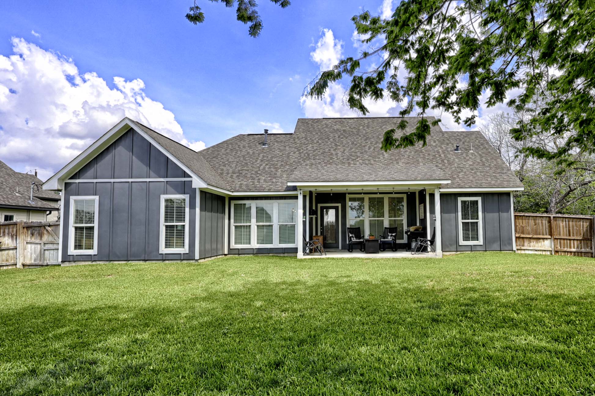 206 East Hinton Road Weimar, TX 78962 - Photo 3 of 22 Rear view of property with board and batten siding, a patio, a fenced backyard, and a shingled roof