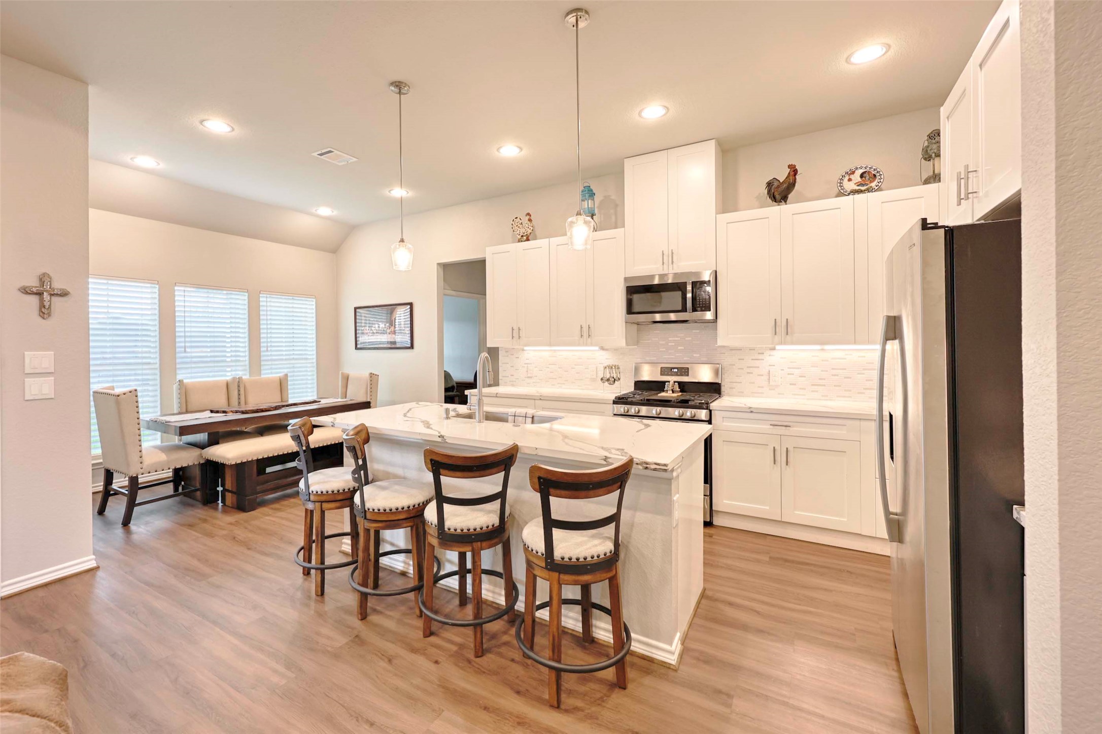 206 East Hinton Road Weimar, TX 78962 - Photo 6 of 22 Kitchen featuring stainless steel appliances, white cabinetry, a breakfast bar, light wood-style floors, and an island with sink