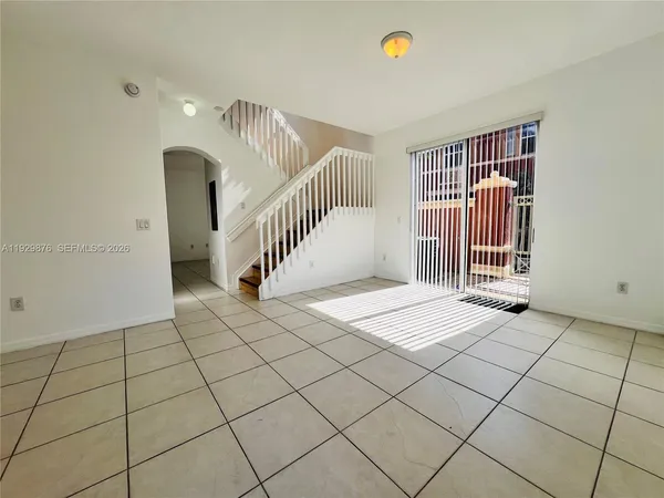 a view of an empty room and staircase a potted plant