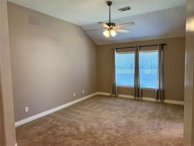 an empty room with chandelier fan