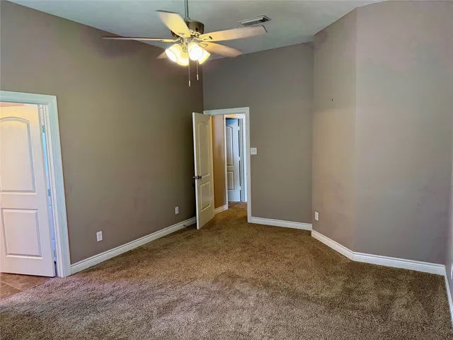an empty room with closet and a chandelier fan