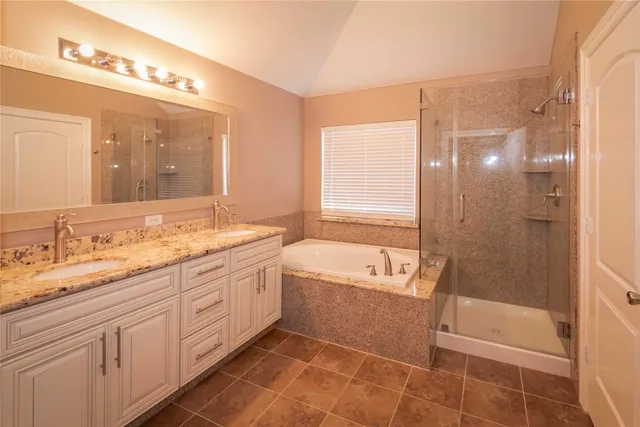 a spacious bathroom with a granite countertop sink a toilet and shower